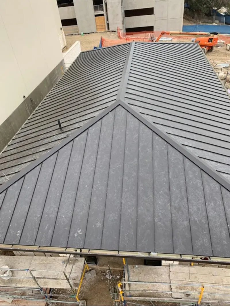 Commercial metal roof construction with crane equipment in Bulverde